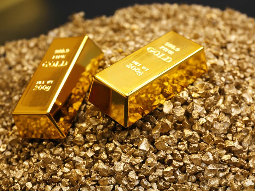 Gold bars resting on a bed of gold grains