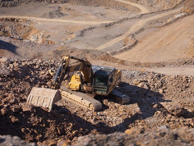 An excavator loading ore in an open-pit mine